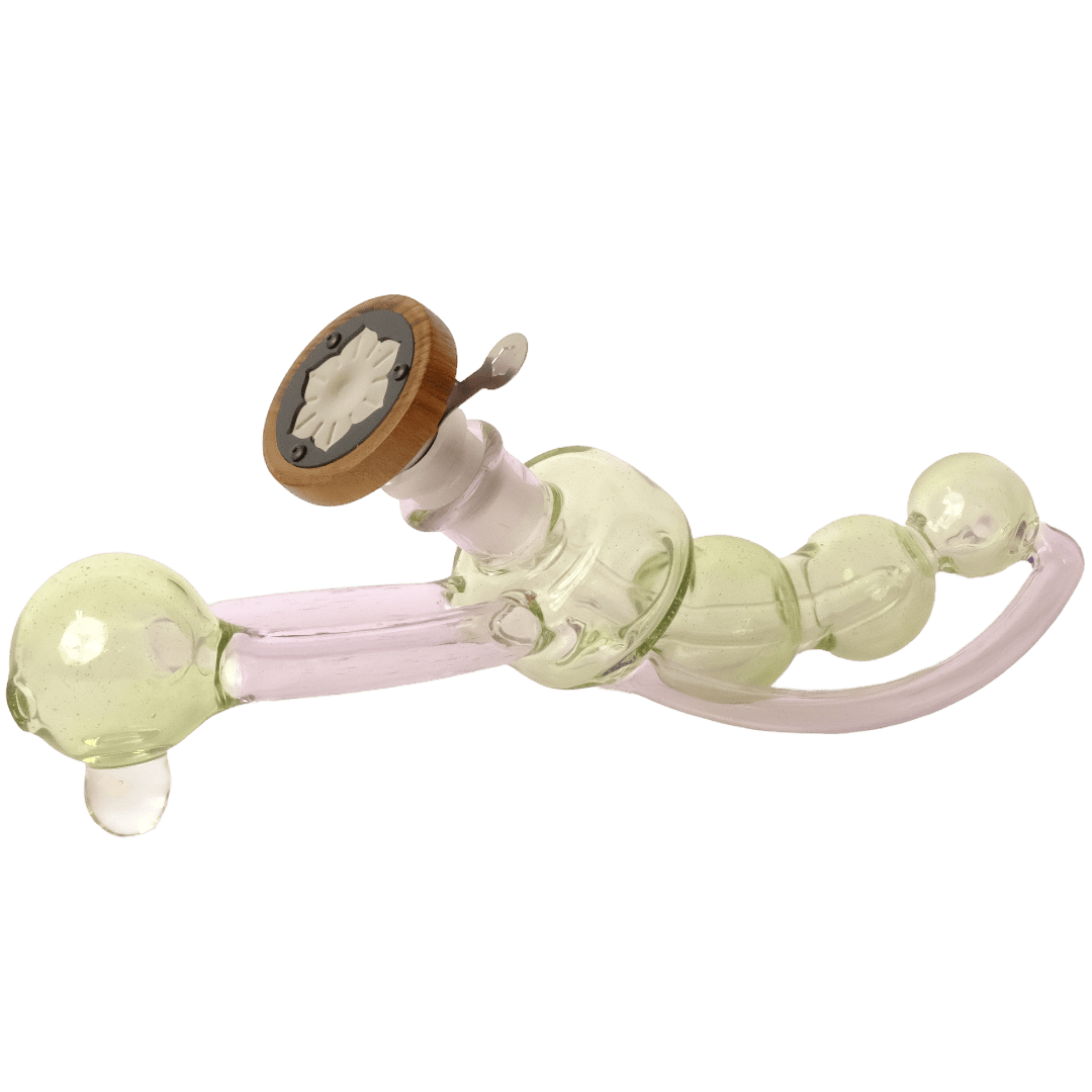 A glass bong with a pale green tinted glass body, a translucent pink curved tube, and a brown wooden mouthpiece with a white patterned center.